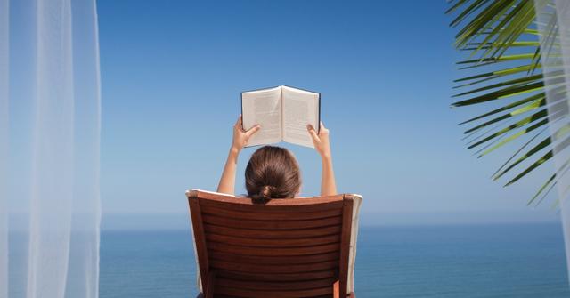 Person reading a book on vacation.