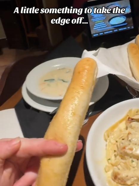 "A little something to take the edge off" trend on TikTok involving a breadstick