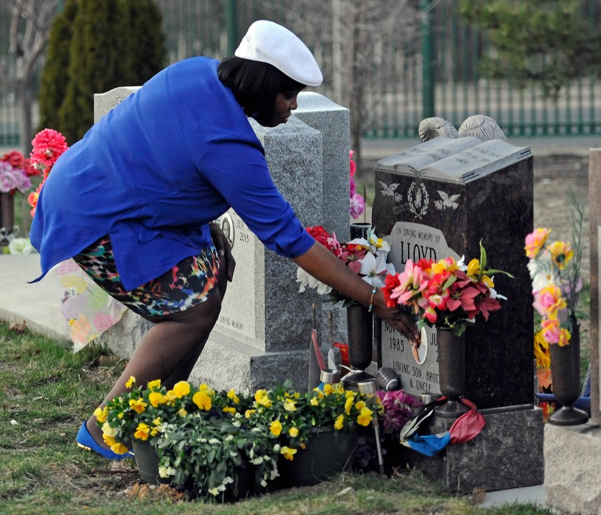 Ursula Ward, mother of Odin Lloyd, places her hand on her son's grave at Oak Lawn Cemetery in Boston on April 15, 2015