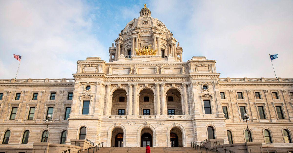The Minnesota state capitol with U.S. and state flags flying on it. 