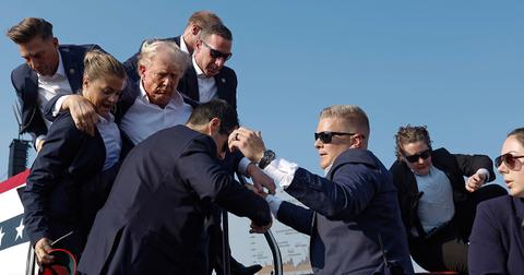 Donald Trump being escorted off the stage at a July 13 political rally.