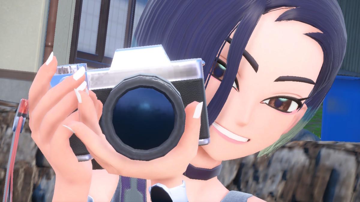 'Pokémon Scarlet & Violet' Close-up of Perrin smiling with her camera.