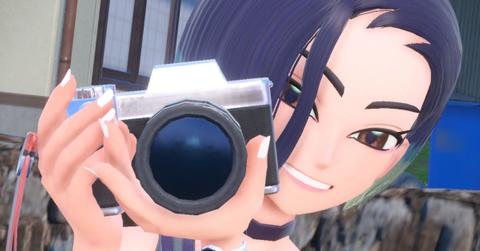 'Pokémon Scarlet & Violet' Close-up of Perrin smiling with her camera.