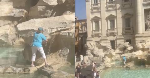 A tourist climbs Trevi Fountain to fill a water bottle