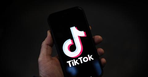 Person holding phone displaying TikTok logo