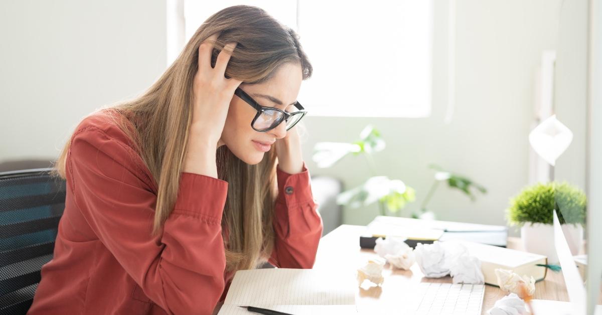 Female writer staring frustratedly at a blank page.