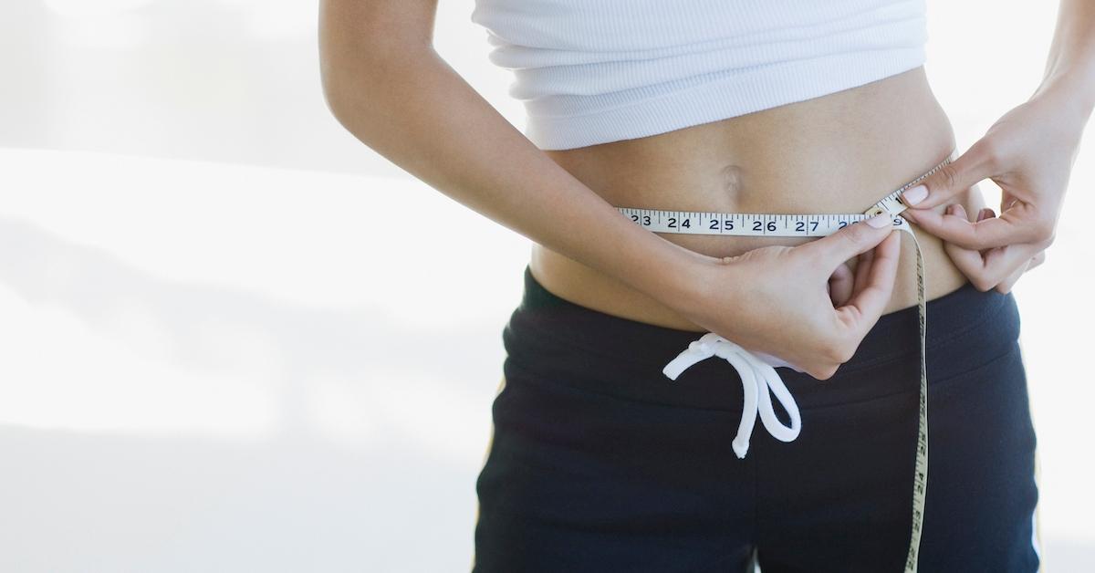 A person measuring their waist