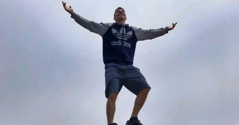 Luigi Mangione stands on a rock