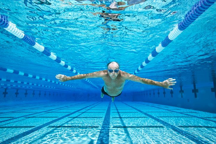 Senior man swimming in pool, underwater view