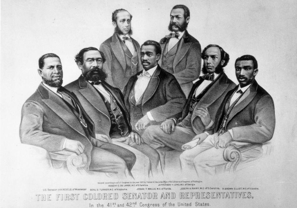 US Senator Hiram Revels (left) with Representatives, from second left Benjamin Turner, Robert De Large, Josiah Walls, Jefferson Long, Joseph Rainey, and Robert Brown Elliot.