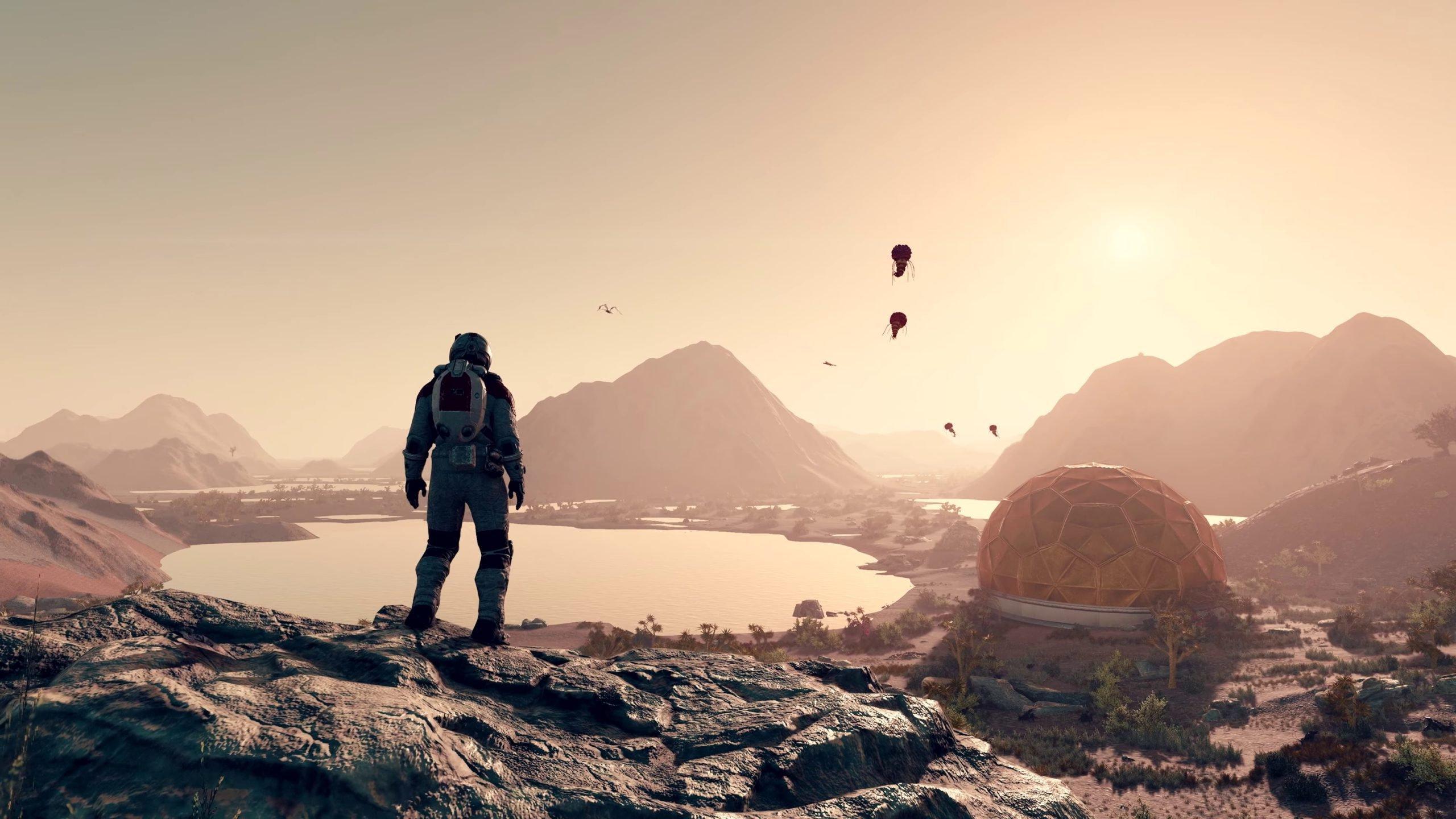 'Starfield' Astronaut standing on a cliff overlooking an outpost and lake.