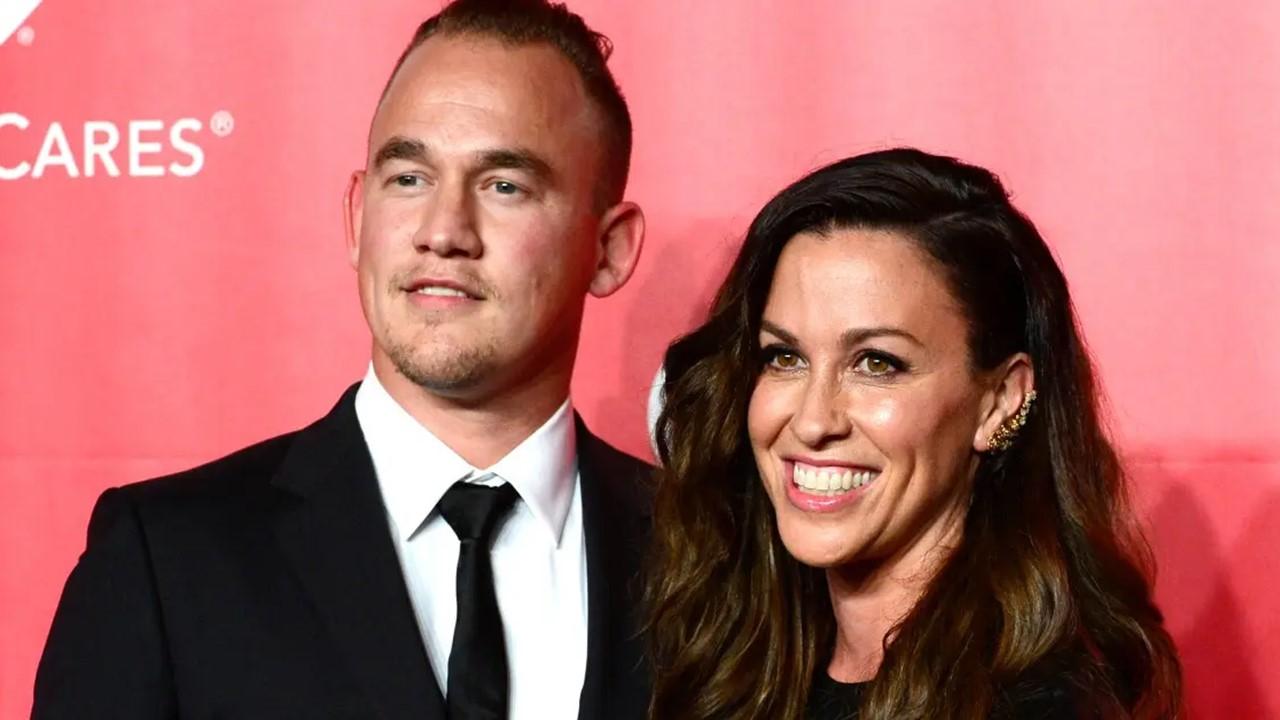 (L-R) Souleye in a black suit, stands next to Alanis Morissette in a black dress at the MusiCares 2015 Person of the Year Gala 