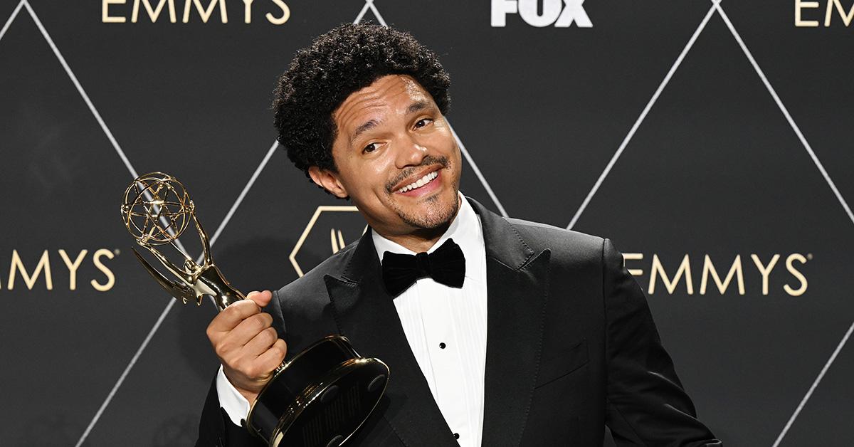 Trevor Noah holding an Emmy at the 75th Emmy Awards. 