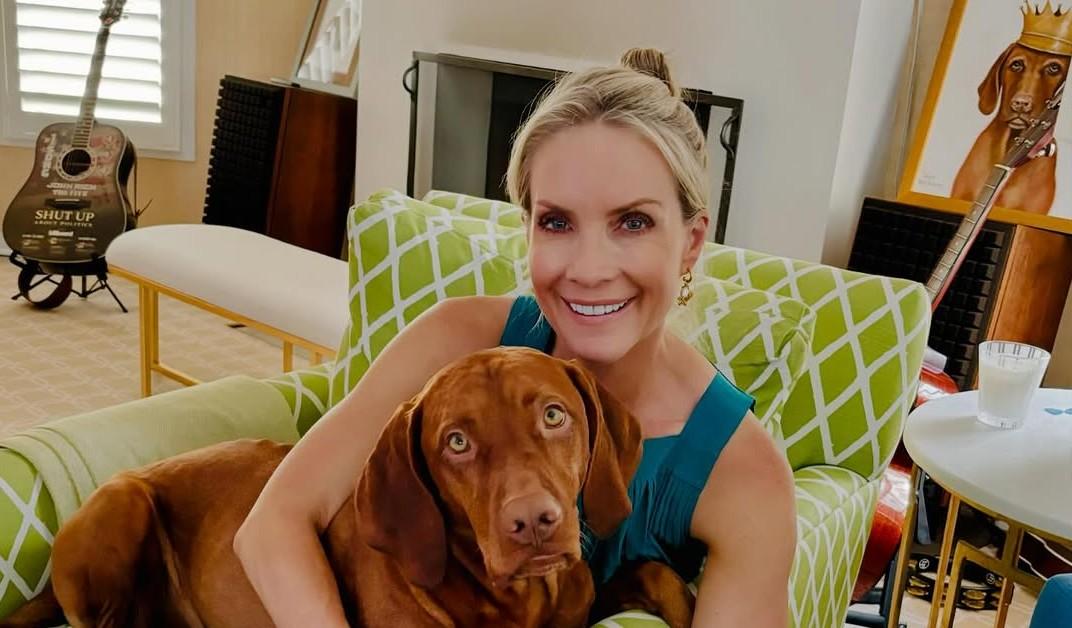 Dana Perino sitting on a chair with a dog