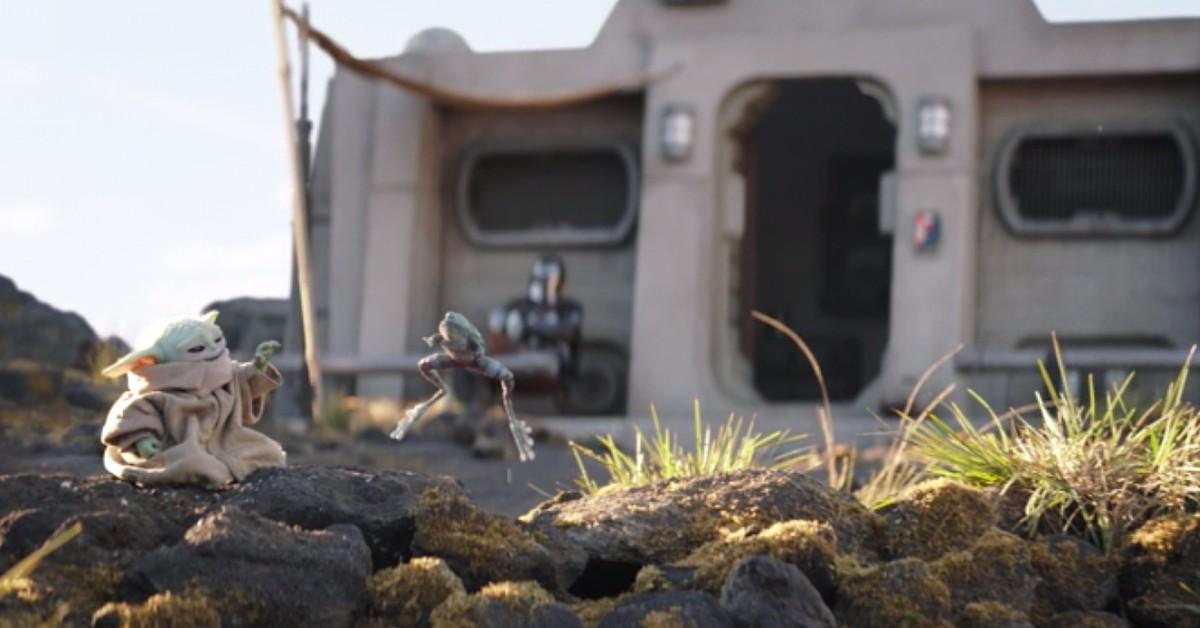 Grogu (L) Force lifts a frog while Din watches in the background in front of their cabin in Nevarro. 