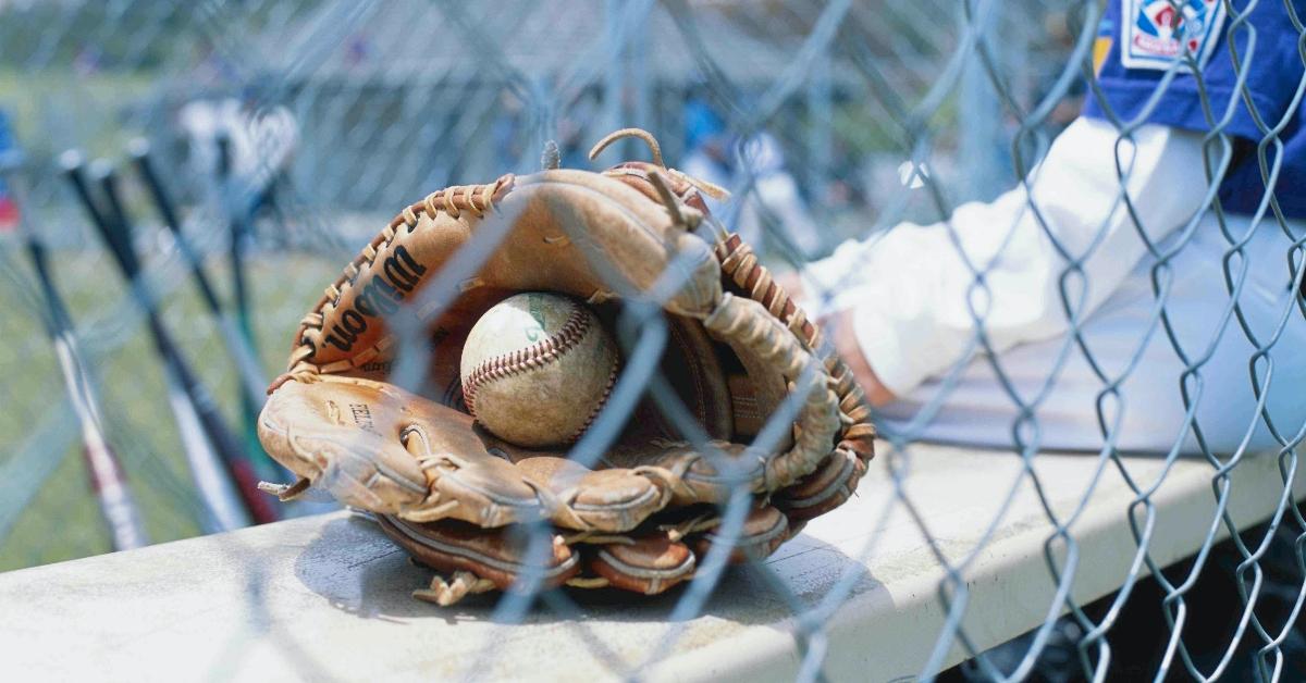 A baseball sits in a baseball glove.