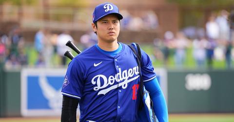 Shohei Ohtani wearing bats on his back in a Dodgers jersey.