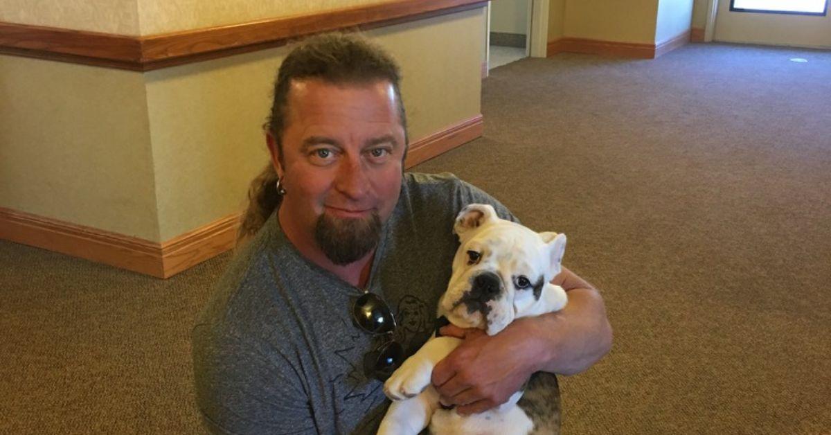 Johnny Dare on his knees with a dog. 