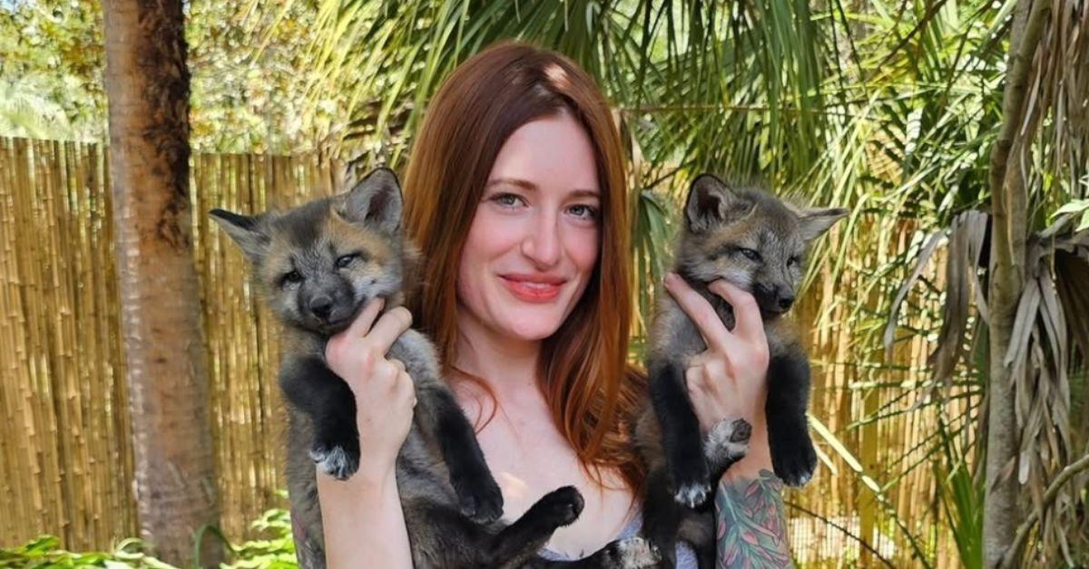 Mikayla Raines holding two foxes. 