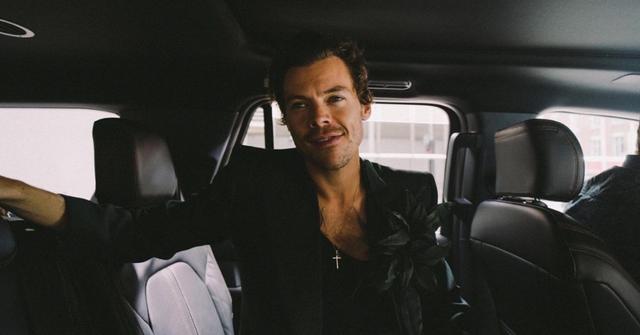 Harry Styles sitting in a car wearing all black.
