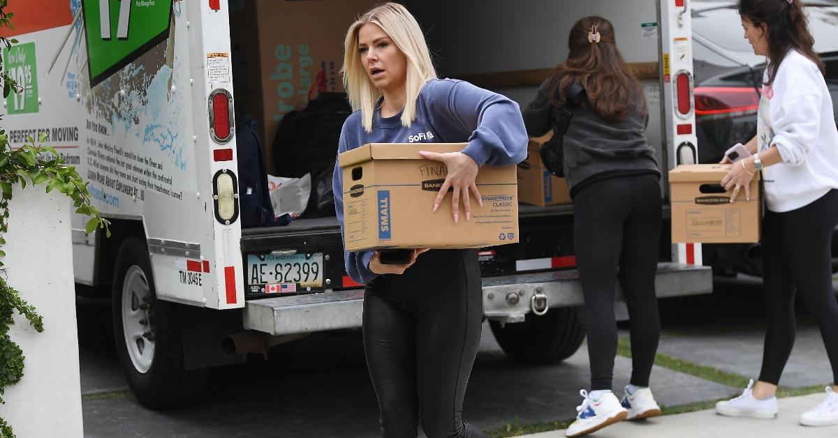 Ariana Madix carries a box from a moving truck