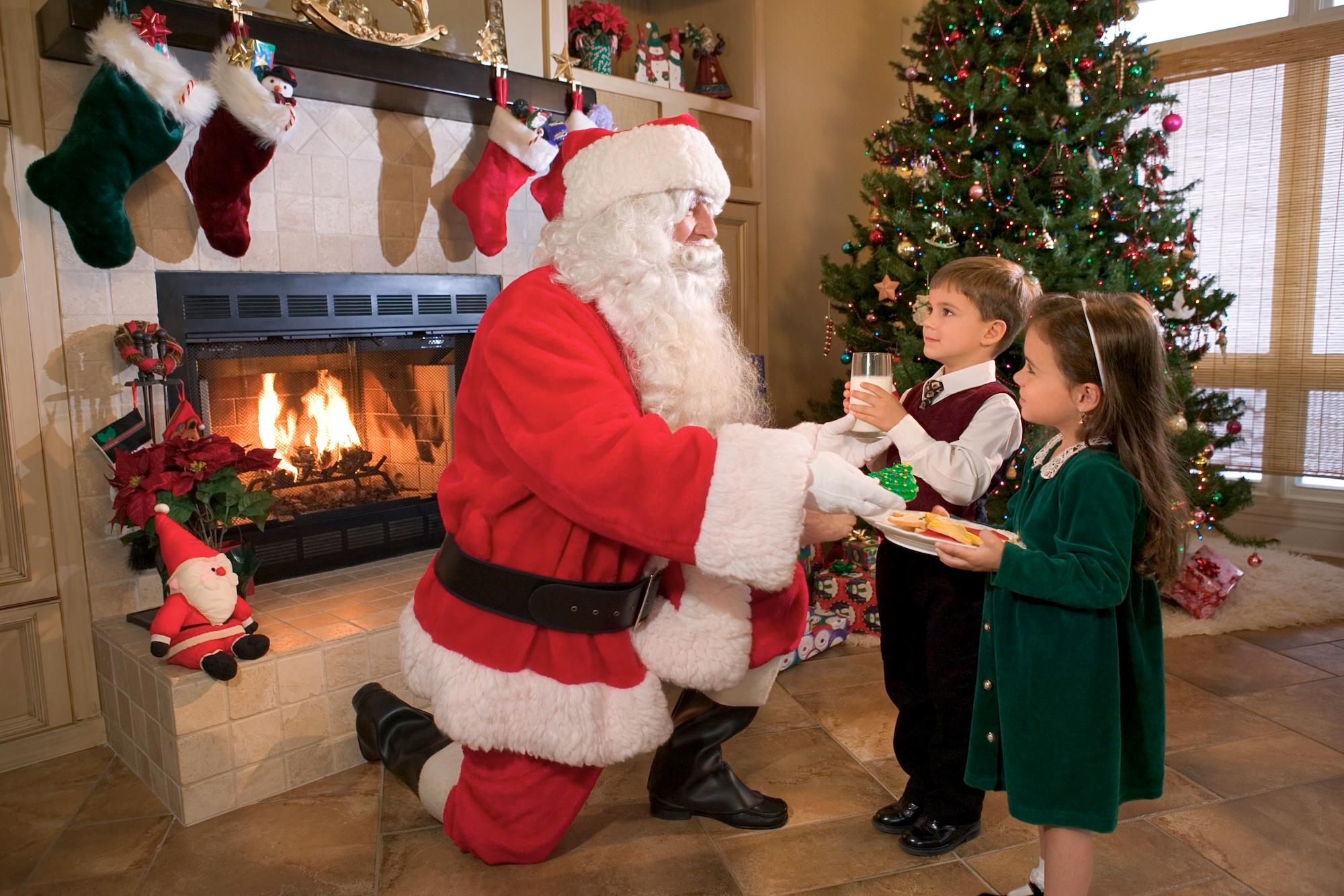 children giving santa milk and christmas cookies