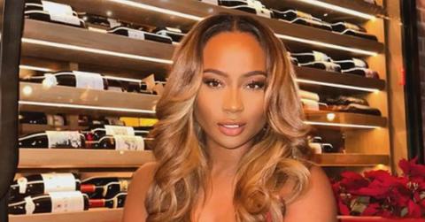 Kayla Nicole poses in front of a wine rack