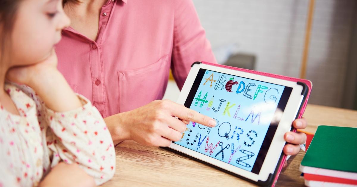 A child learning their ABCs on a tablet.