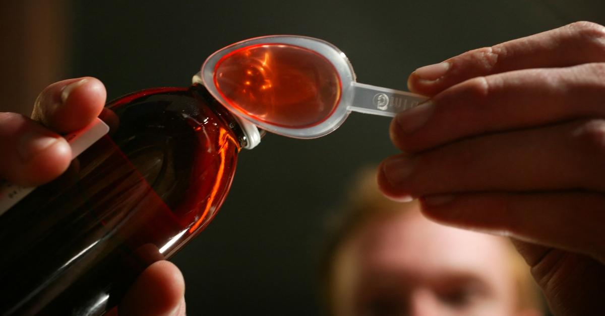 Cough syrup being poured into a spoon