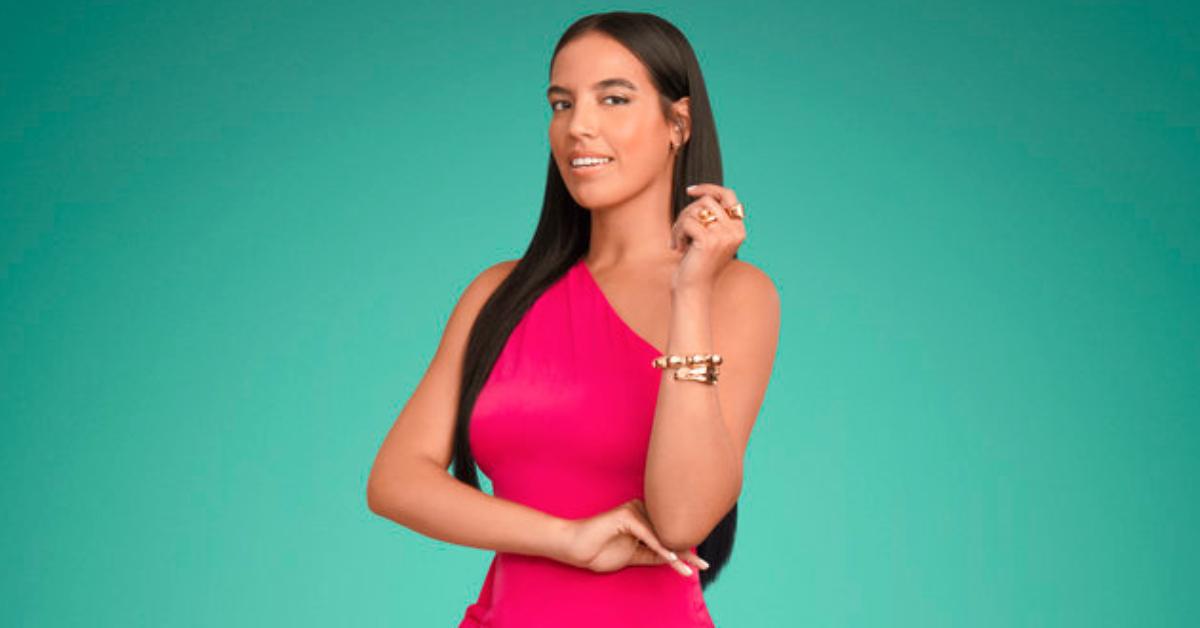 Danielle Olivera smiles and poses for Season 8 of 'Summer House' in a one shoulder neon pink dress.