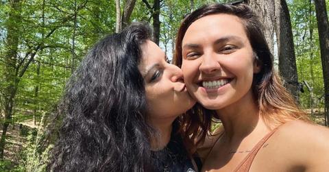 Bria kissing Chrissy on the cheek in the woods