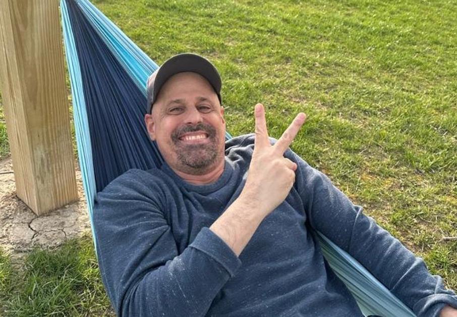 Gino relaxing in a hammock wearing a hat