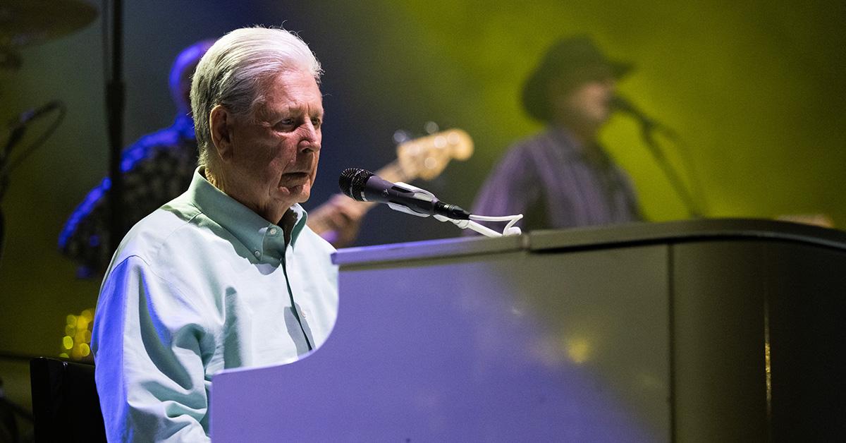 Brian Wilson playing piano on stage. 