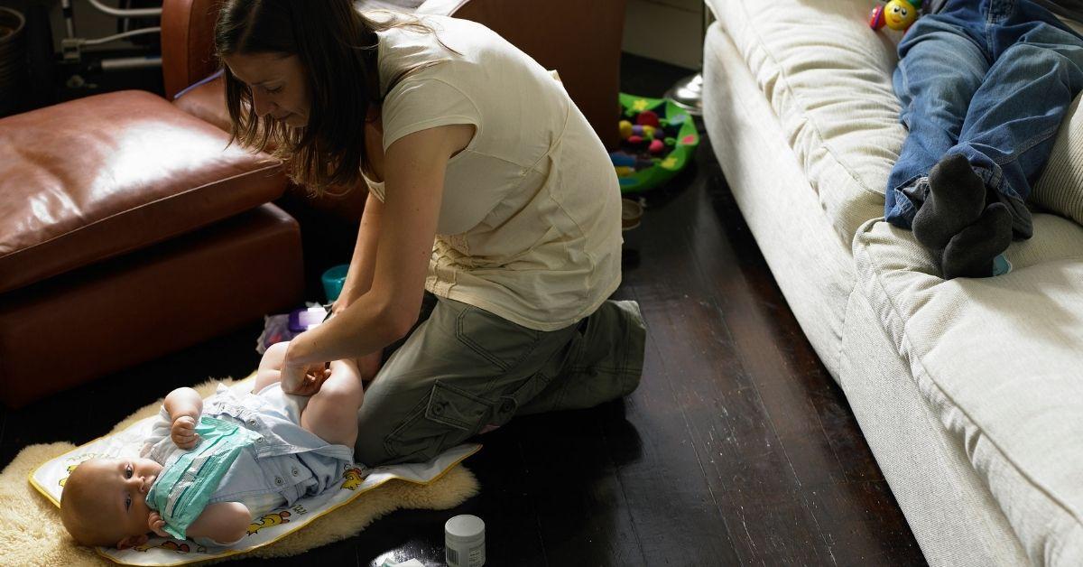 Mom changes baby while dad sits on couch