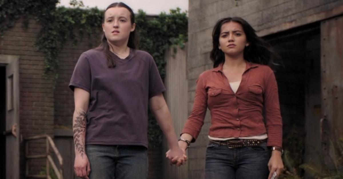 Ellie and Dina hold hands in The Last of Us.