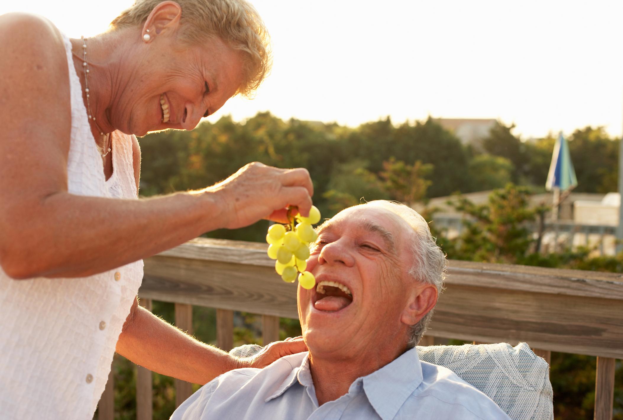 Woman feeding man grapes