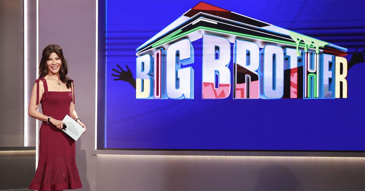 Julie Chen in a red dress with a screen that says Big Brother. 