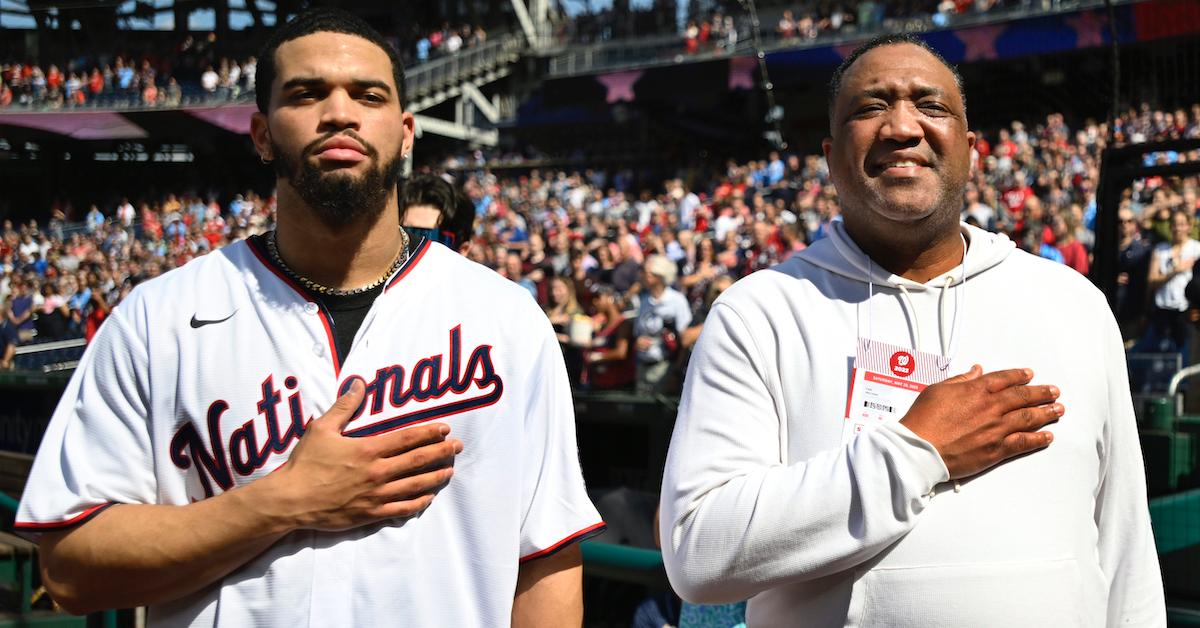 Heisman Trophy winner Caleb Williams, left, stands for the national anthem with his father Carl Williams at Nationals Park before a game with the Detroit Tigers on May 20, 2023 in Washington, DC