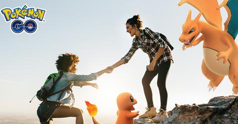 'Pokémon GO' Trainer helping another climb up a cliff.