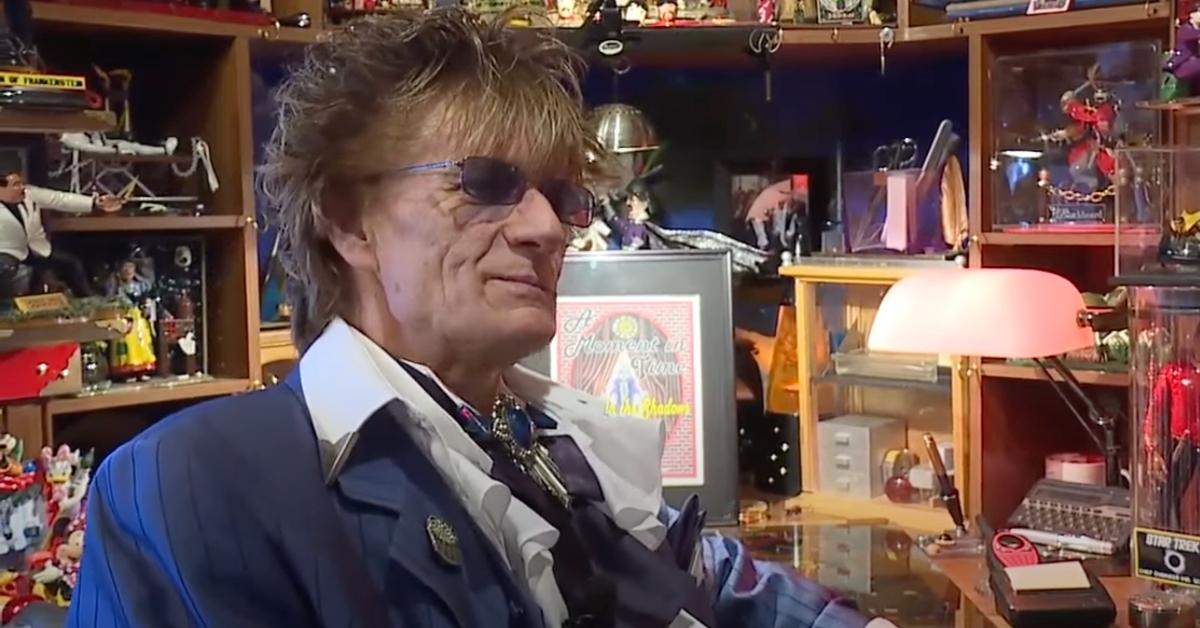 Randy Fowler sits in a room surrounded by toys and various memorabilia