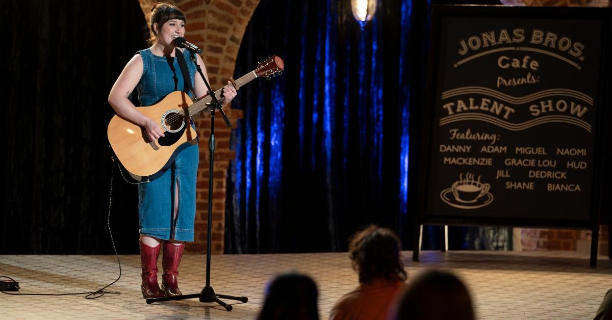 Gracie Lou with a guitar on-stage on Claim to Fame