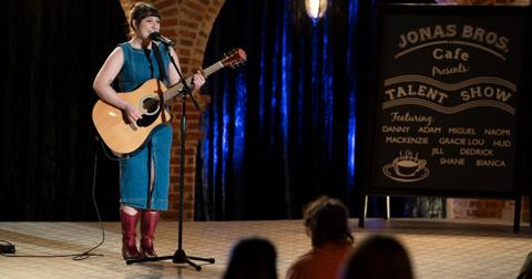 Gracie Lou with a guitar on-stage on Claim to Fame
