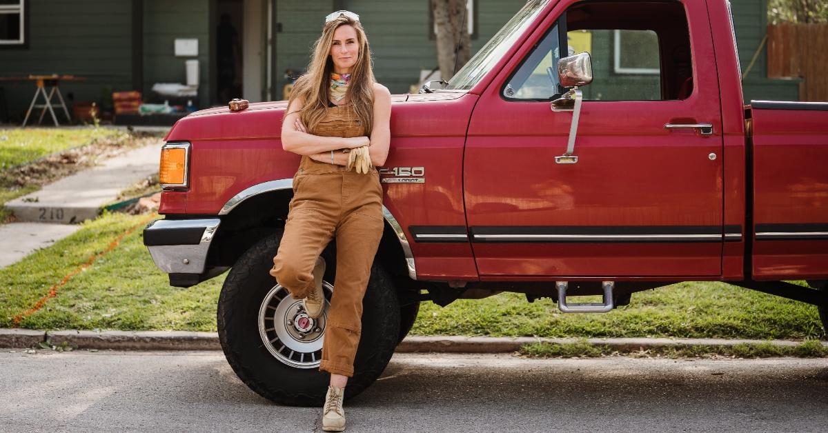 Kim Wolfe from 'Why the Heck Did I Buy This House?' in front of a red truck.