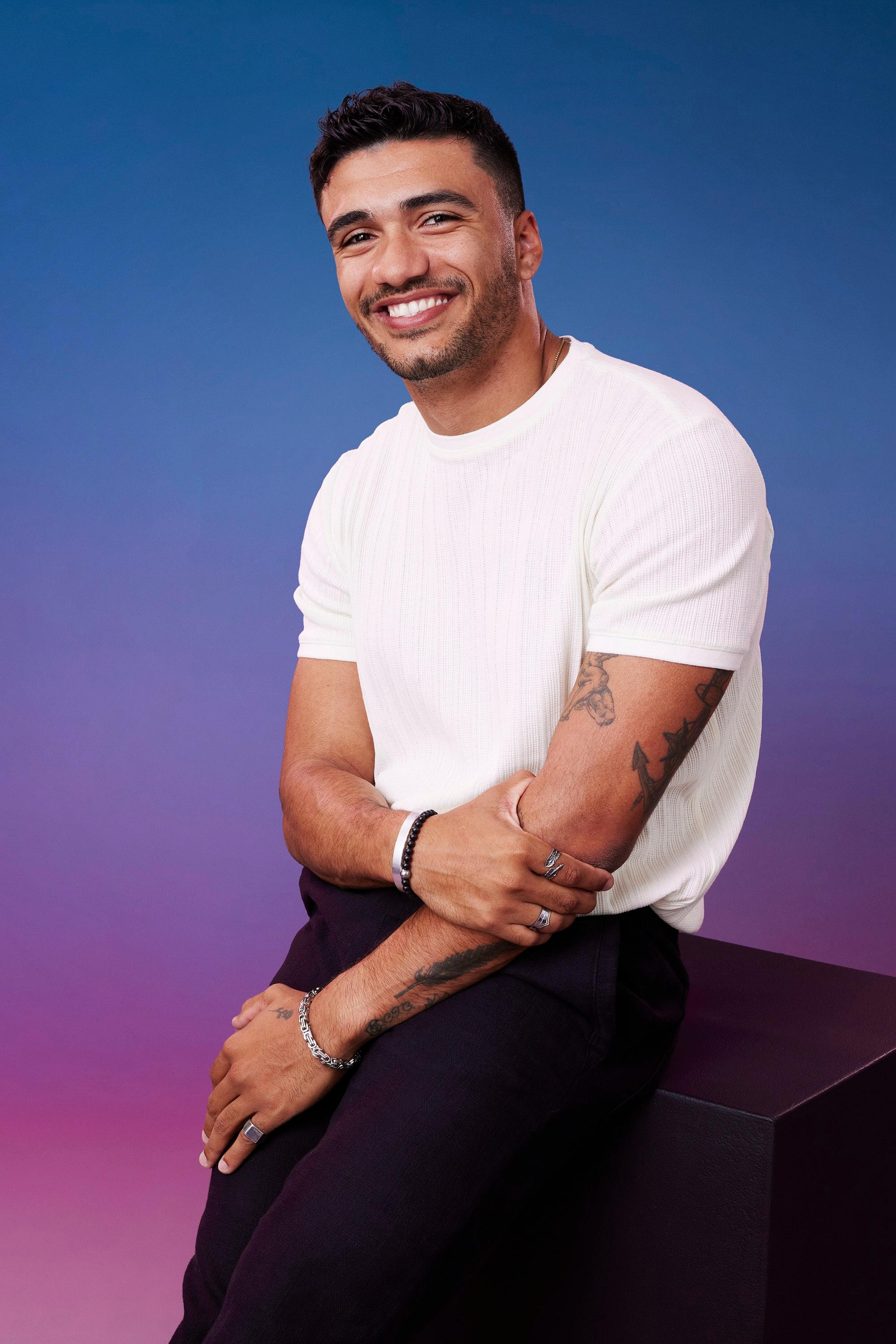 Jonathon poses in front of a blue-purple ombré background for his official 'The Bachelorette' Season 21 portrait.