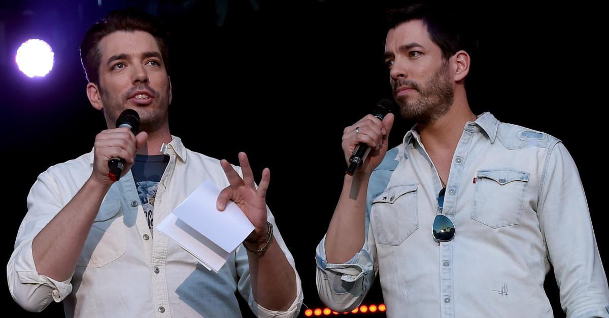 Jonathan and Drew Scott holding microphones