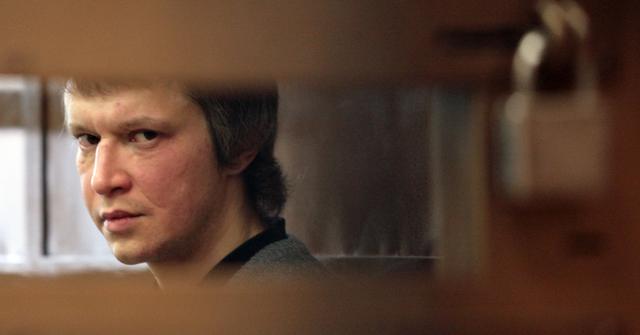 Alexander Pichushkin looks on from a cell in a Moscow court room awaiting his sentence, Oct. 29, 2007.
