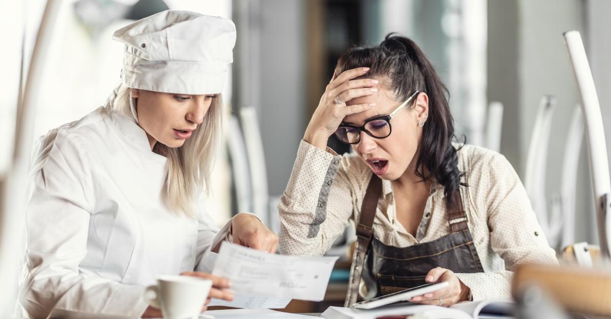 female chef and server look at paper shocked