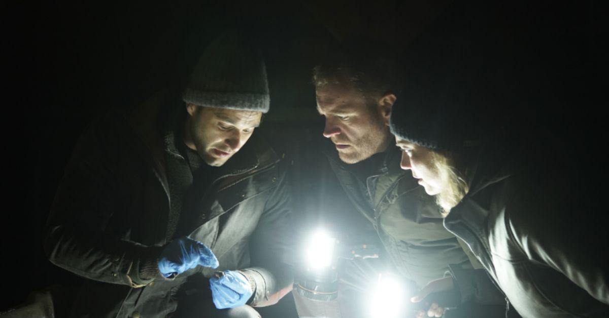 Phil Torres, Heather Amaro, and Josh Gates examine something with flashlights at night on 'Expedition X'