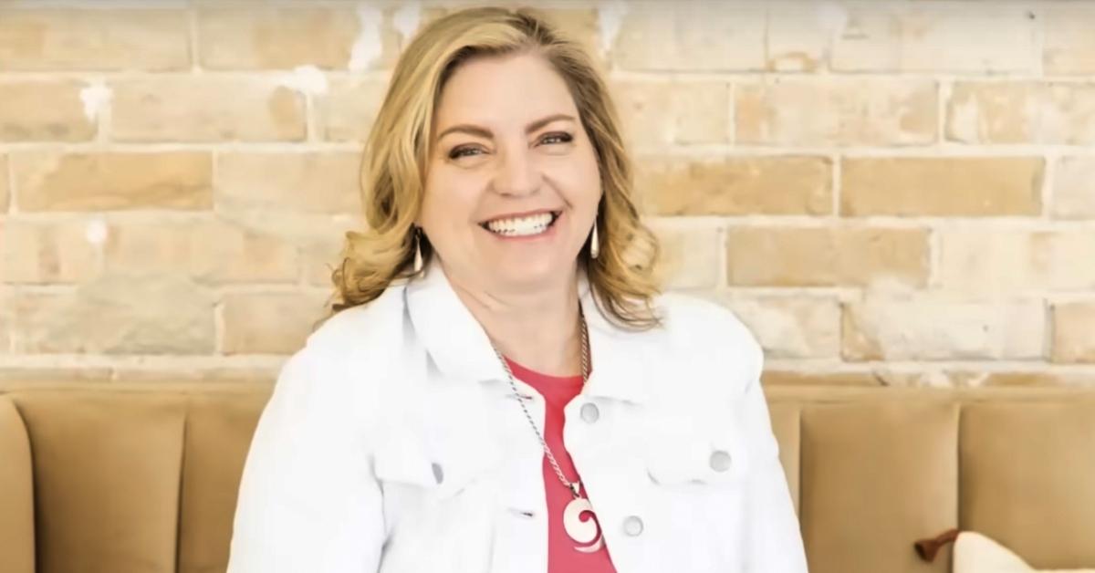 Jodi Hildebrandt sits on a couch, smiling