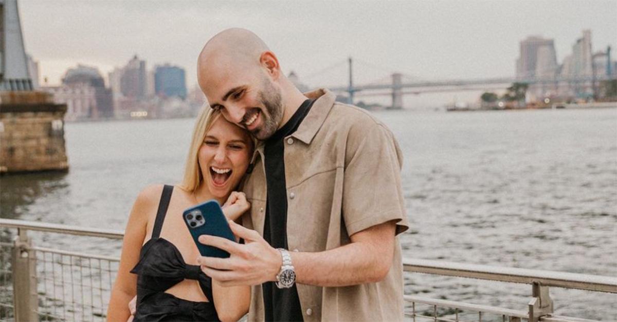 Jared and Brittany March in New York City looking at his phone. 